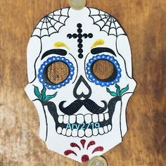 a white sugar skull with blue eyes and a spider web on it