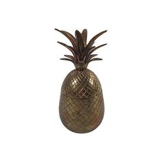 a gold pineapple shaped vase sitting on top of a table