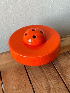 an orange object sitting on top of a wooden floor