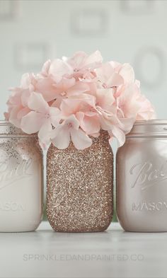 three mason jars with pink flowers in them