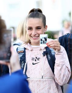 a woman holding up a photo in front of her face and taking a selfie