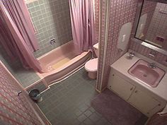 a small bathroom with pink and green tiles on the shower, toilet, sink and bathtub