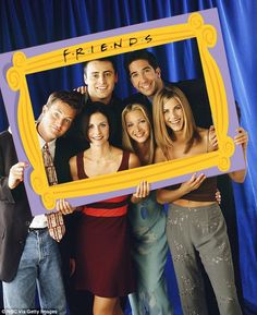 friends posing in front of a photo frame