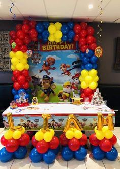 a birthday party with balloons and decorations in the shape of paw patrol on a table