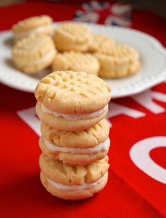 a stack of cookies sitting on top of a table next to a plate of cookies