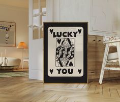 an image of a lucky playing card in the corner of a room with white walls and wood flooring