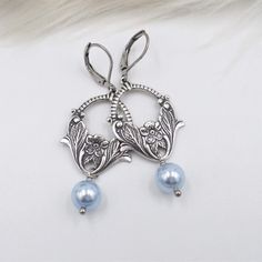 For this pair of new earrings - I used light baby pastel blue top quality crystal cored pearls, which dangle below antique silver plated brass stamped metal connectors.  These sweet little flower basket pieces are so well done with lots of gorgeous antiqued silver details.  The ear wires are stainless steel lever backs, bringing the total length to 2 1/4 inches.  Thank you - shop my collection here:  www.etsy.com/shop/hhjewelrydesigns Nickel-free Blue Pearl Earrings Gift, Elegant Light Blue Crystal Earrings For Gift, Elegant Light Blue Pearl Jewelry, Elegant Light Blue Nickel-free Earrings, Light Blue Pearl Jewelry For Gift, Blue Pearl Dangle Earrings, Handmade Blue Pearl Earrings, Elegant Handmade Light Blue Earrings, Light Blue Metal Earrings For Gift