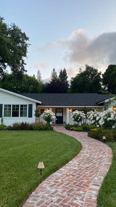 a brick path leading to a white house