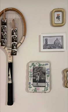 a tennis racket hanging on the wall next to pictures and other items that have been placed around it