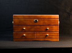 a wooden dresser sitting on top of a black surface