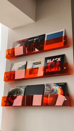 three orange shelves with various records on them