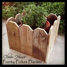 a wooden planter filled with potted plants