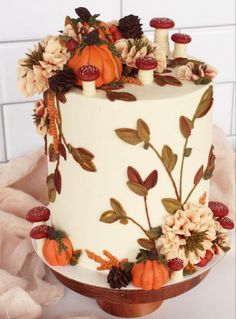 a white cake decorated with flowers and pumpkins