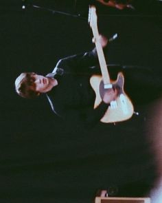 a man is playing an electric guitar on stage