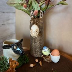 a wooden table topped with fake animals and eggs