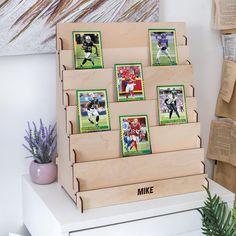 a wooden display case with football cards and photos on the front, along with a potted plant next to it