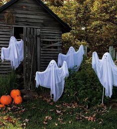 halloween decorations with ghost heads and pumpkins in front of an outhouse