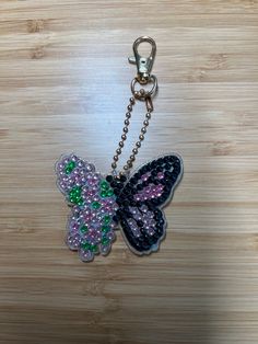 a key chain with a butterfly shaped bead on it's back and side