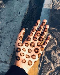 a person's hand with hendix on it and flowers painted on the palm