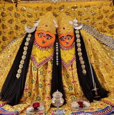 two people dressed in yellow and black are standing next to each other with their faces painted orange