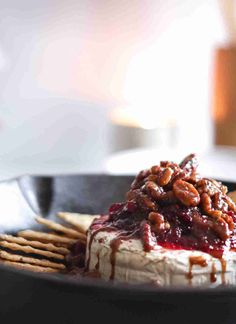 a black plate topped with food and crackers