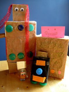 a cardboard robot sitting on top of a wooden table