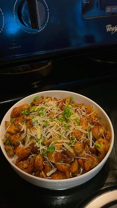 a white bowl filled with food sitting on top of a stove