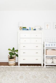 a white dresser sitting next to a baby crib