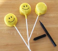 three lollipops with smiley faces on them