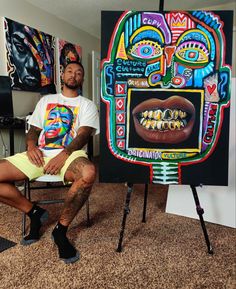 a man sitting in front of a painting on a easel next to a chair