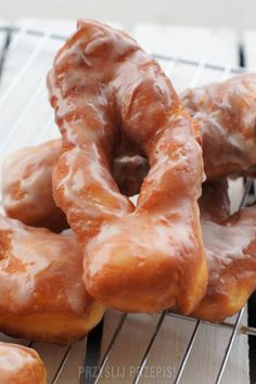 several glazed donuts on a cooling rack