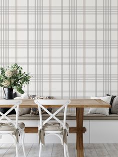 a dining room table with two chairs and a bench in front of a plaid wall