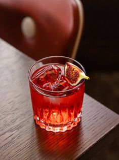 a red drink sitting on top of a wooden table