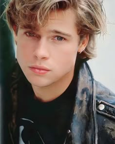 a close up of a person wearing a leather jacket and looking at the camera with a serious look on his face