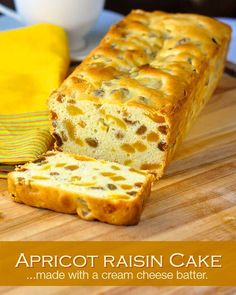 a loaf of apricot raisin cake sitting on top of a wooden cutting board