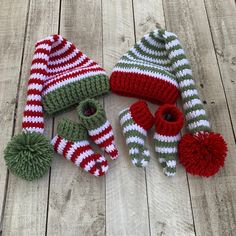 several knitted hats and mittens laying on top of a wooden floor