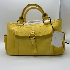 Authentic, Never Before Used Handbag Made With Beautiful Dyed Yellow Leather From The Luxurious French Brand Celine. Both Stylish And Useful, This Bag Is Perfect For Spring And Summer Days And The Perfect Size To Hold Your Items. There Is A Slight Tarnish On The Middle Magnetic Button On The Bag, But Is Easily Covered By The Leather Pullover Band Down The Middle. Comes With Certificate Of Authenticity, A Dust Cover, And An Informational Booklet Straight From Celine. Designer Yellow Bag With Top Carry Handle, Chic Yellow Satchel With Dust Bag, Designer Yellow Satchel With Handles, Designer Yellow Satchel For Everyday Use, Designer Yellow Satchel For Everyday, Designer Yellow Satchel With Double Handle, Celine Bags, French Brands, How To Make Handbags