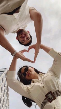 two people making a heart shape with their hands