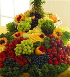 a large display of fresh fruits and vegetables on a table in front of a window