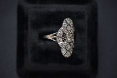 Sensational antique diamond dinner/cocktail/statement ring crafted in platinum, ready to show up and show off all night long.PlatinumSize 6.25/6.5 (resizable)5.1gEst. 1.5ctw of mixed old cut diamonds, including a very cushiony elongated OMC in the center.Measures 1 1/2 in. longWant to see more photos or videos? Have questions about resizing or layaway? Find me on Instagram @lunamerchant and send me a DM. Antique Diamond Ring For Vintage Events, Silver Diamond Ring For Vintage Events, Estate Style Silver Diamond Ring With Diamond Cut, Estate Silver Diamond Ring With Diamond Cut, Estate Style Silver Diamond Ring With Brilliant Cut, Estate Diamond Ring With Diamond Cut, Estate Style Diamond Ring With Diamond Cut, Silver Diamond Ring With Brilliant Cut In Estate Style, Estate Diamond Ring With Center Stone