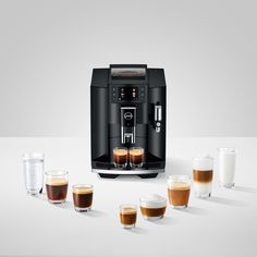 an espresso machine is shown with four glasses