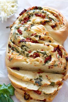 an artisan bread with cheese and herbs on it next to some other food items