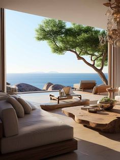 a living room filled with furniture and a large window overlooking the ocean in front of it