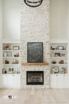 a fireplace with white built in shelves and a chalkboard on the wall above it