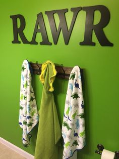 towels are hanging on the wall in front of a sign that says rawr with dinosaurs