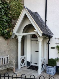 a small white building with a wooden bench next to it