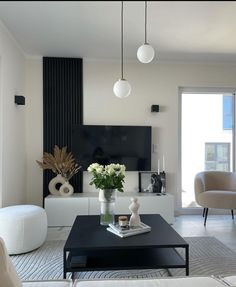 a living room filled with furniture and a flat screen tv mounted on the wall above it