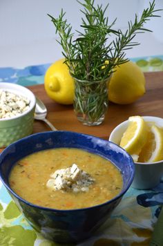 a bowl of soup on a table with lemons