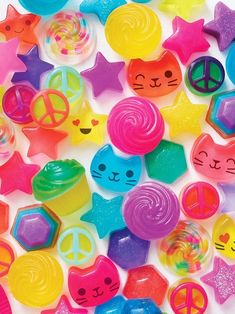 a pile of assorted plastic toys on a white surface with peace signs and cats