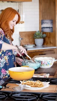 a woman with red hair is cooking in the kitchen